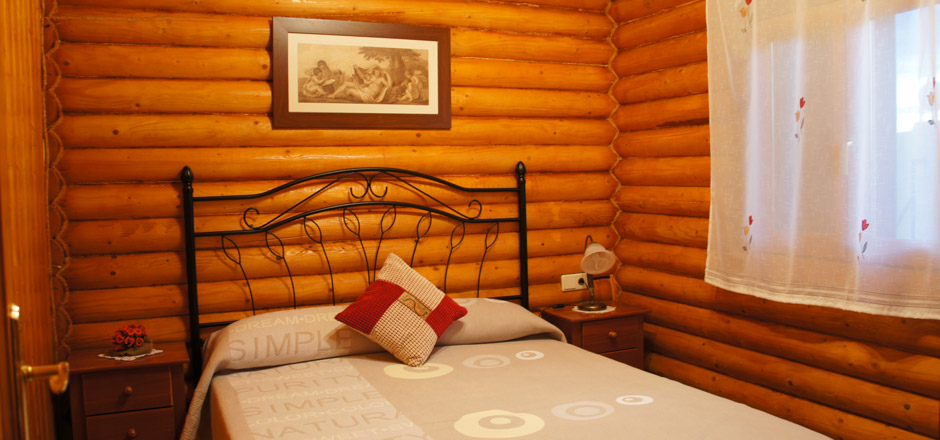 Dormitorio Casa Rural con una cama de matrimonio y paredes de madera